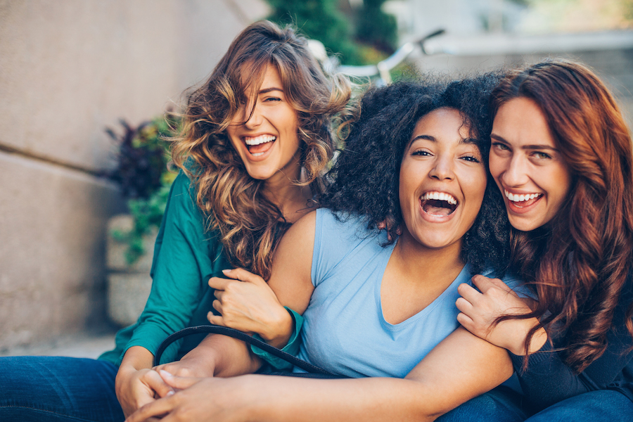 Three smiling young women on a dental blog about preventive dentistry.